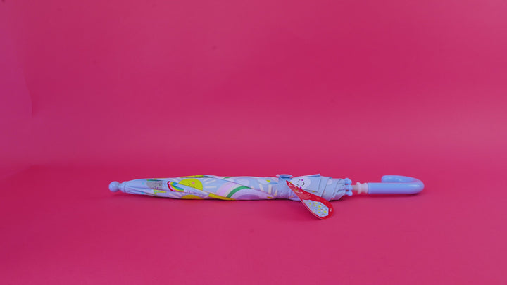 A video of a clear children's umbrella with a colorful illustrated print of animals, plants, and nature motifs, featuring a magenta background.